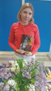 Poetka Anna Czartoszewska pokazuje tomik poezji w kameralnym wnętrzu sali kawiarni Gminnego Ośrodka Kultury w Szepietowie